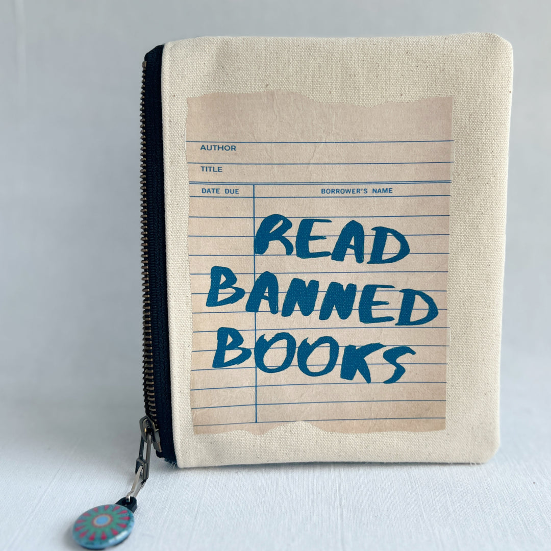 padded canvas zip bag with a linen library card and the words, read banned books, plus a colorful zipper pull and lining