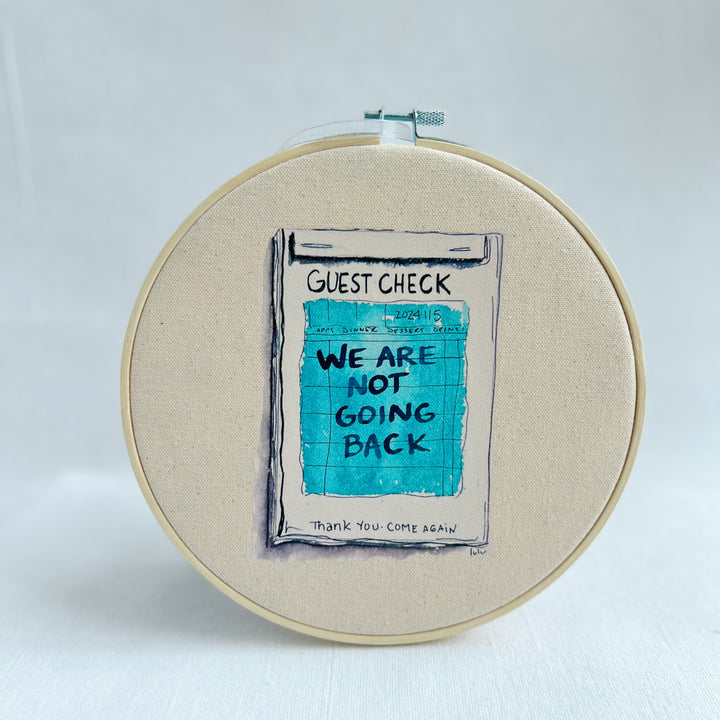 oatmeal linen canvas with a guest check design in deep blue-grey, with the words, we are not going back