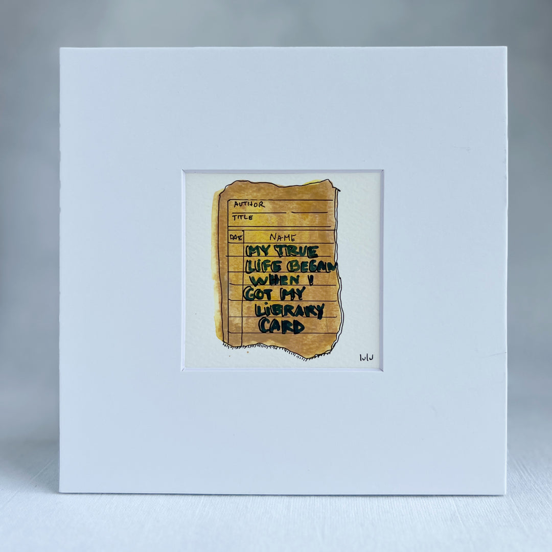 an original watercolor painting depicting a torn vintage library checkout card in shades of yellow with the words, my true life began when I got my library card, matted in white