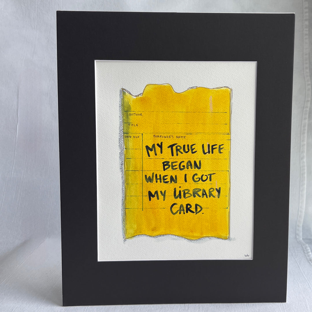 an original watercolor painting depicting a torn vintage library checkout card in shades of yellow with the words, my true life began when I got my library card, matted in black