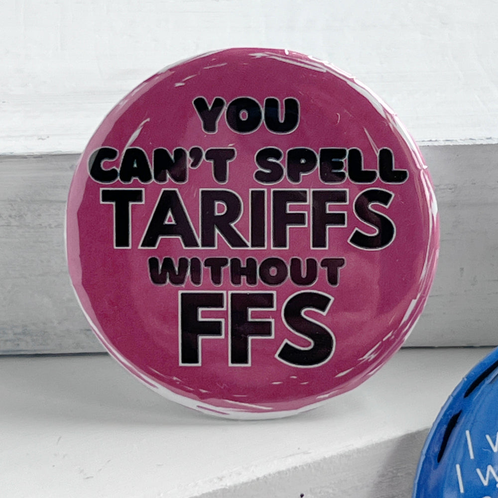 round pinback button with a pink background and the words, "you can't spell TARIFFS without FFS" in black lettering.