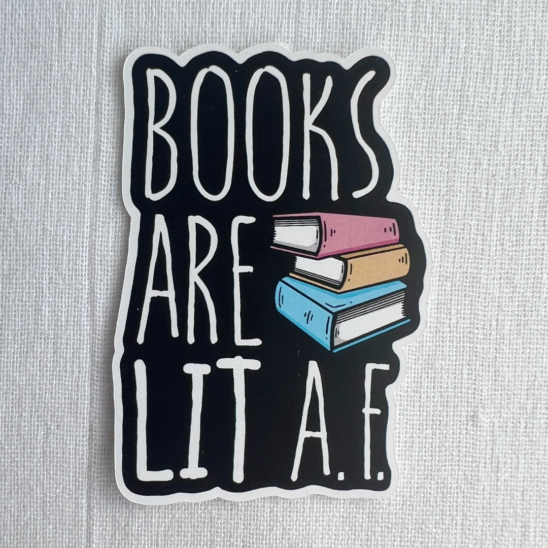 3 inch by 2 inch sticker with black background and white lettering, reading, Books are LIT A.F.  Also contains a design with a 3-book stack.