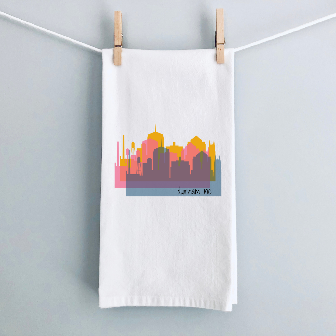 A white kitchen towel with a triple view of the downtown Durham NC skyline