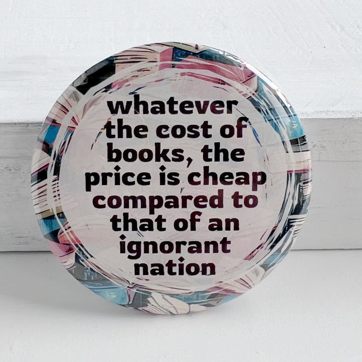 round pinback buttn with a background of colorful books, and the words, "whatever the cost of books, the price is cheeap compared to that of an ignorant nation."