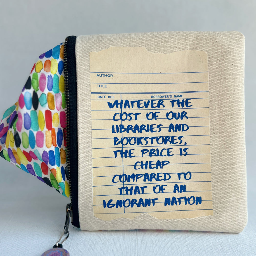 padded canvas zip bag with a linen library card and the words, whatever the cost of our libraries and bookstores, the prices is cheap compared to that of an ignorant nation, plus a colorful zipper pull and lining