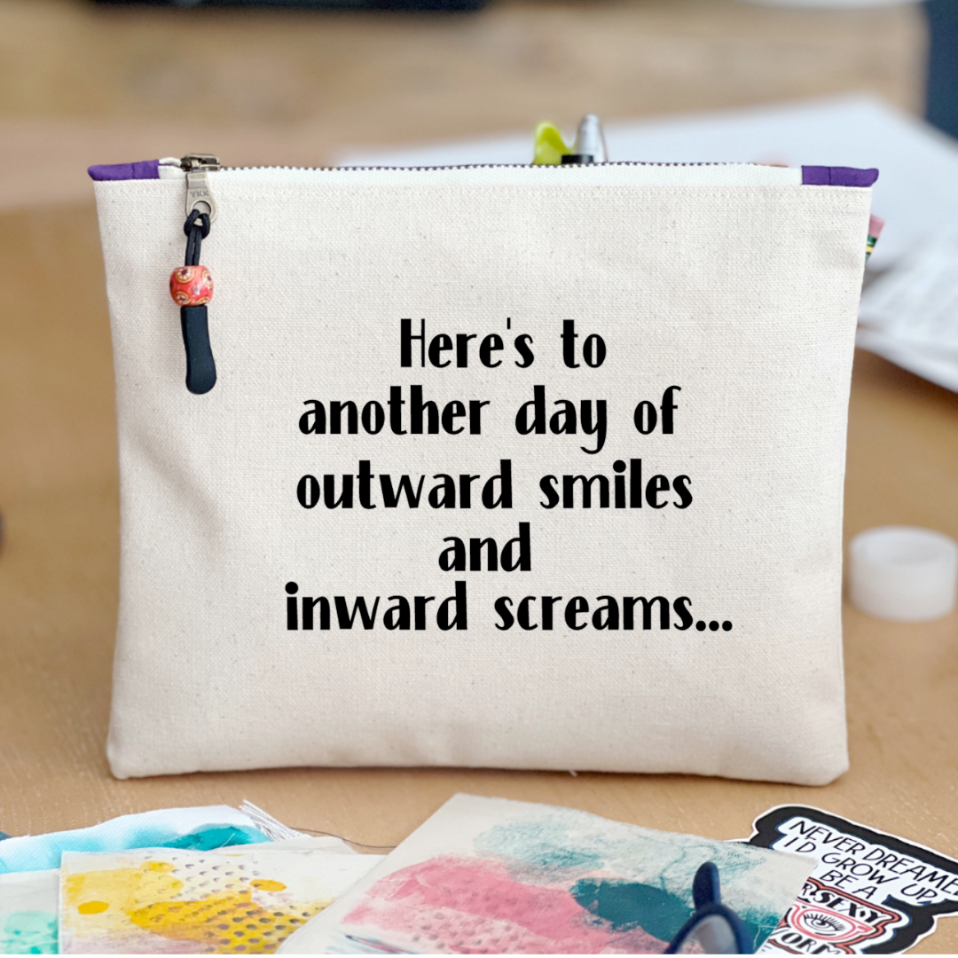 square canvas zip pouch with the words, Here's to another day of outward smiles and inward screams.'