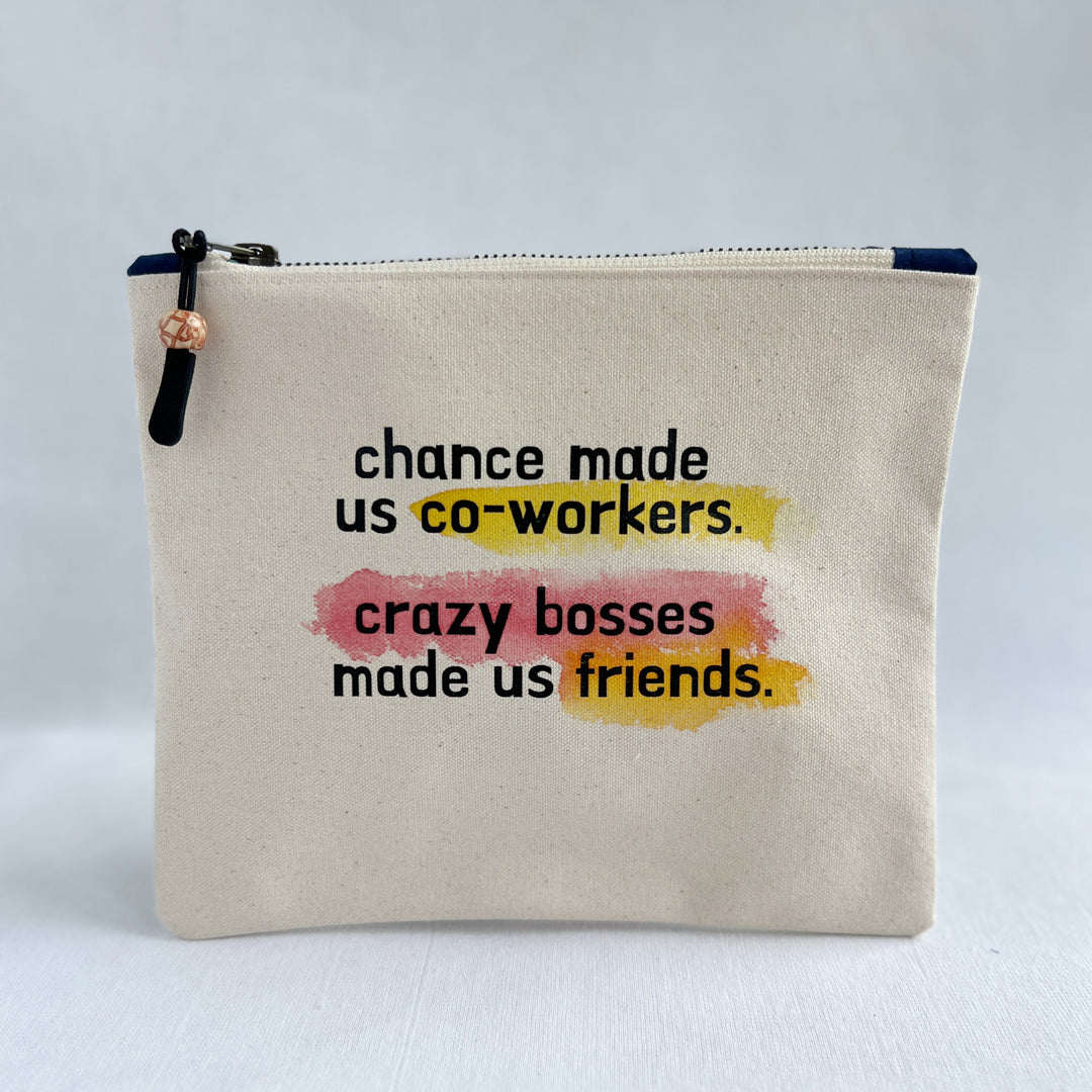 square canvas zip bag with the words, chance made us co-workers, crazy bosses made us friends. painted with swashes of red and yellow.