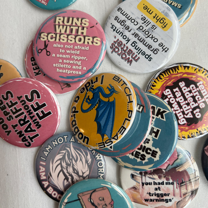 a group of multicolored pin back buttons scattered across a white background