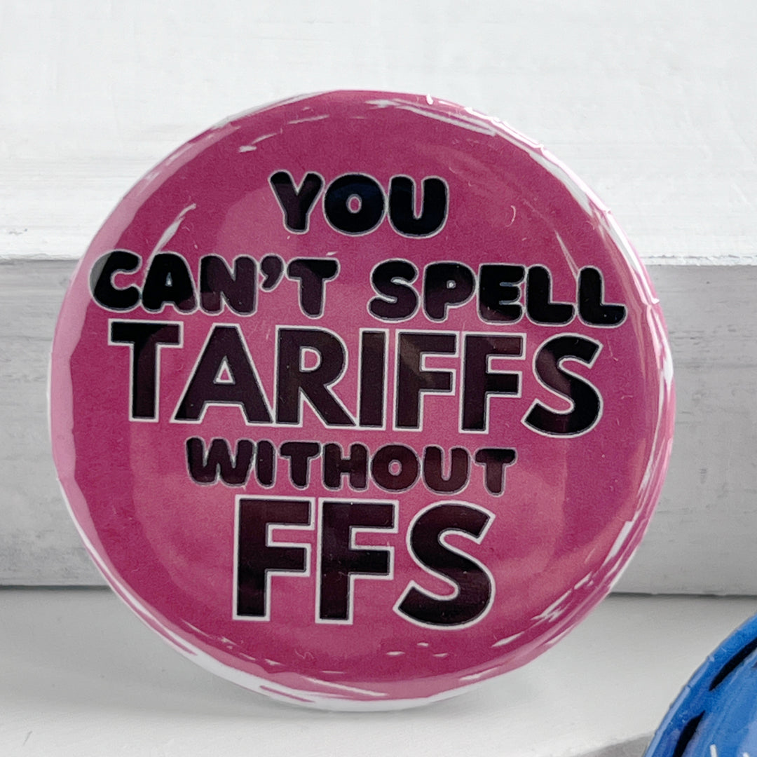 round pinback button with a pink background and the words, "you can't spell TARIFFS without FFS" in black lettering.