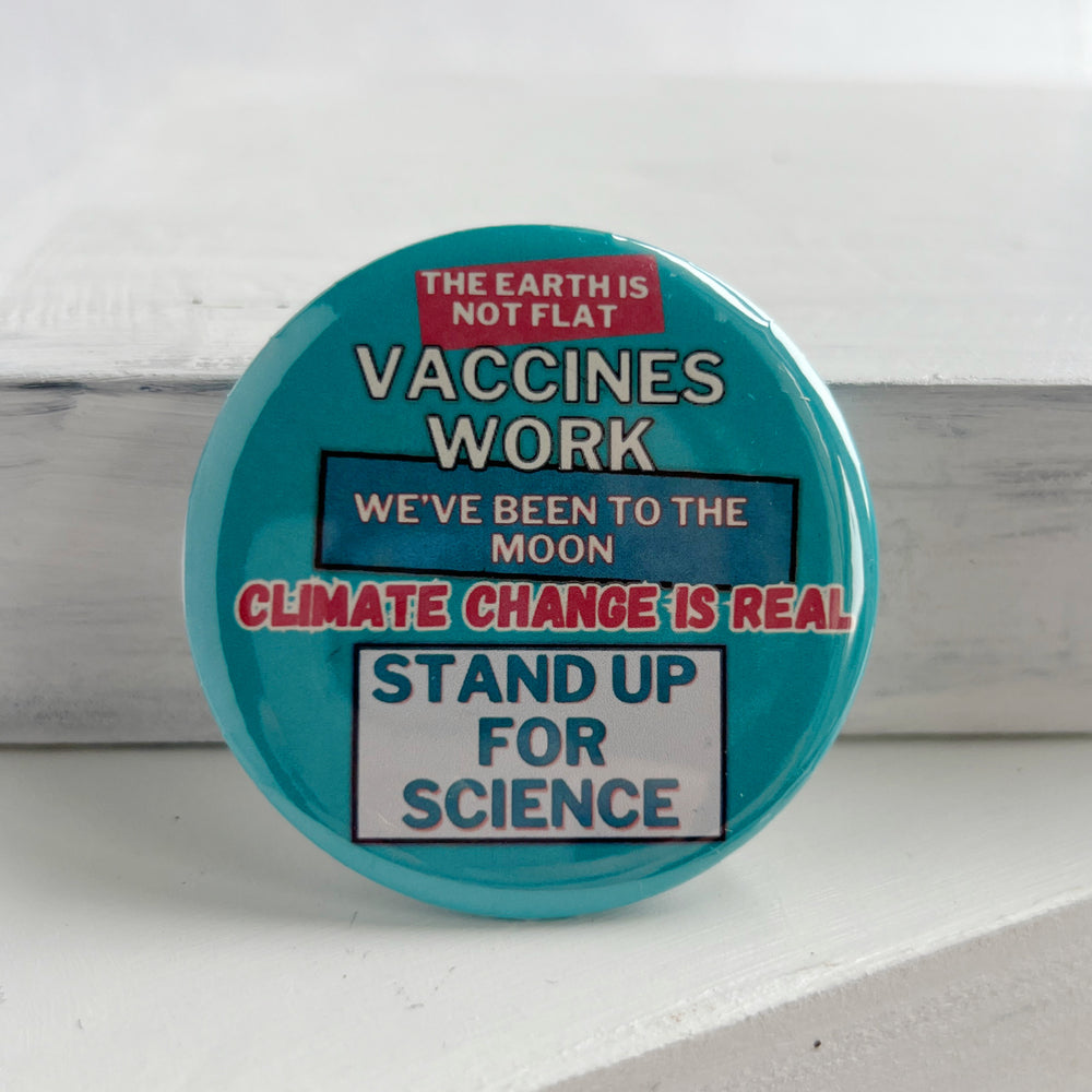 round, robin's egg blue pinback button on a white background with the words, "the earth is not flat. vaccines work. we've been to the moon. climate change is real. stand up for science."