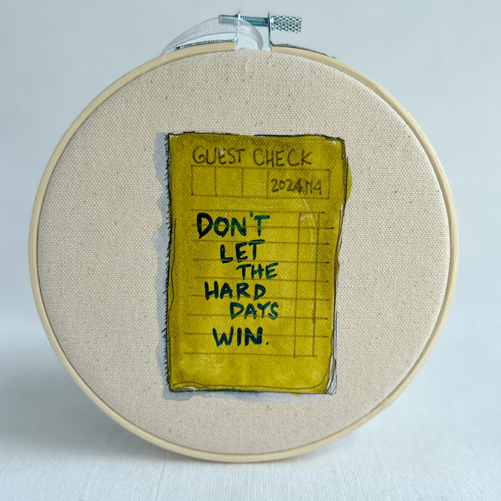 oatmeal linen canvas with a guest check design in deep citron, with the words, Don't let the hard days win