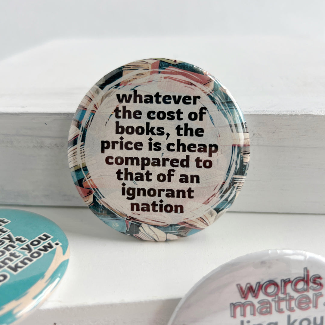 round pinback buttn with a background of colorful books, and the words, "whatever the cost of books, the price is cheeap compared to that of an ignorant nation."