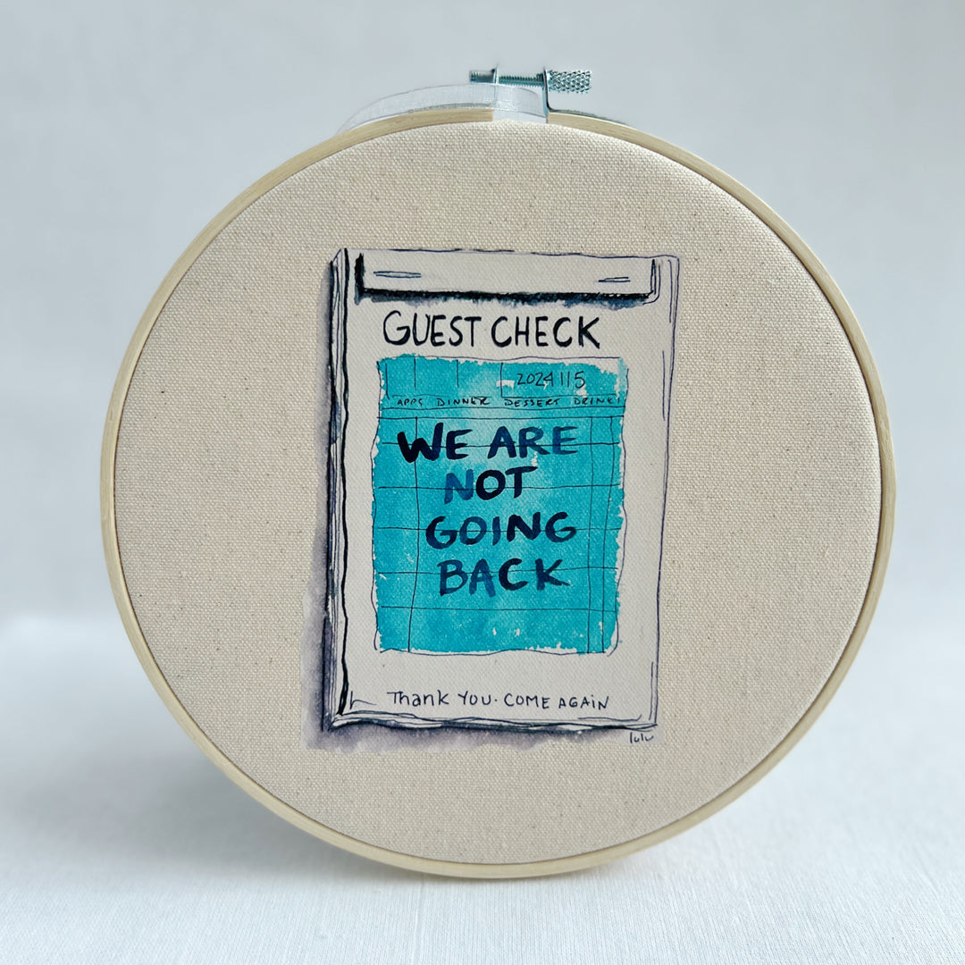 oatmeal linen canvas with a guest check design in deep blue-grey, with the words, we are not going back