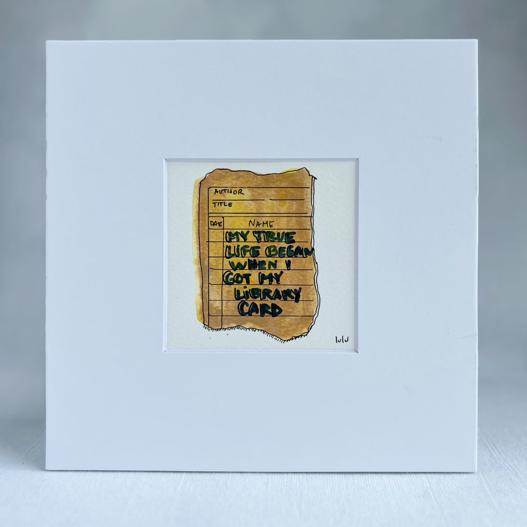 an original watercolor painting depicting a torn vintage library checkout card in shades of yellow with the words, my true life began when I got my library card, matted in white