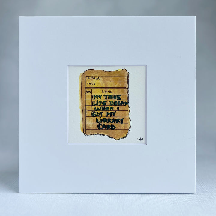 an original watercolor painting depicting a torn vintage library checkout card in shades of yellow with the words, my true life began when I got my library card, matted in white