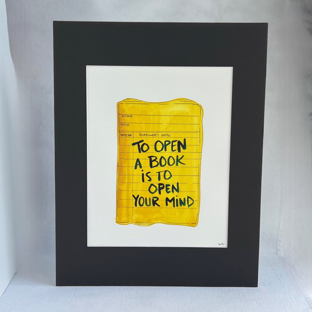 an original watercolor painting depicting a torn vintage library checkout card in shades of yellow with the words, to open a book is to open your mind, matted in black