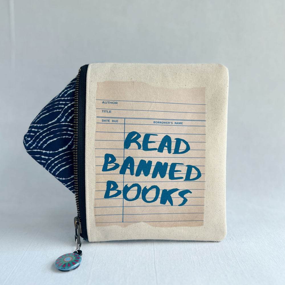 padded canvas zip bag with a linen library card and the words, read banned books, plus a colorful zipper pull and lining