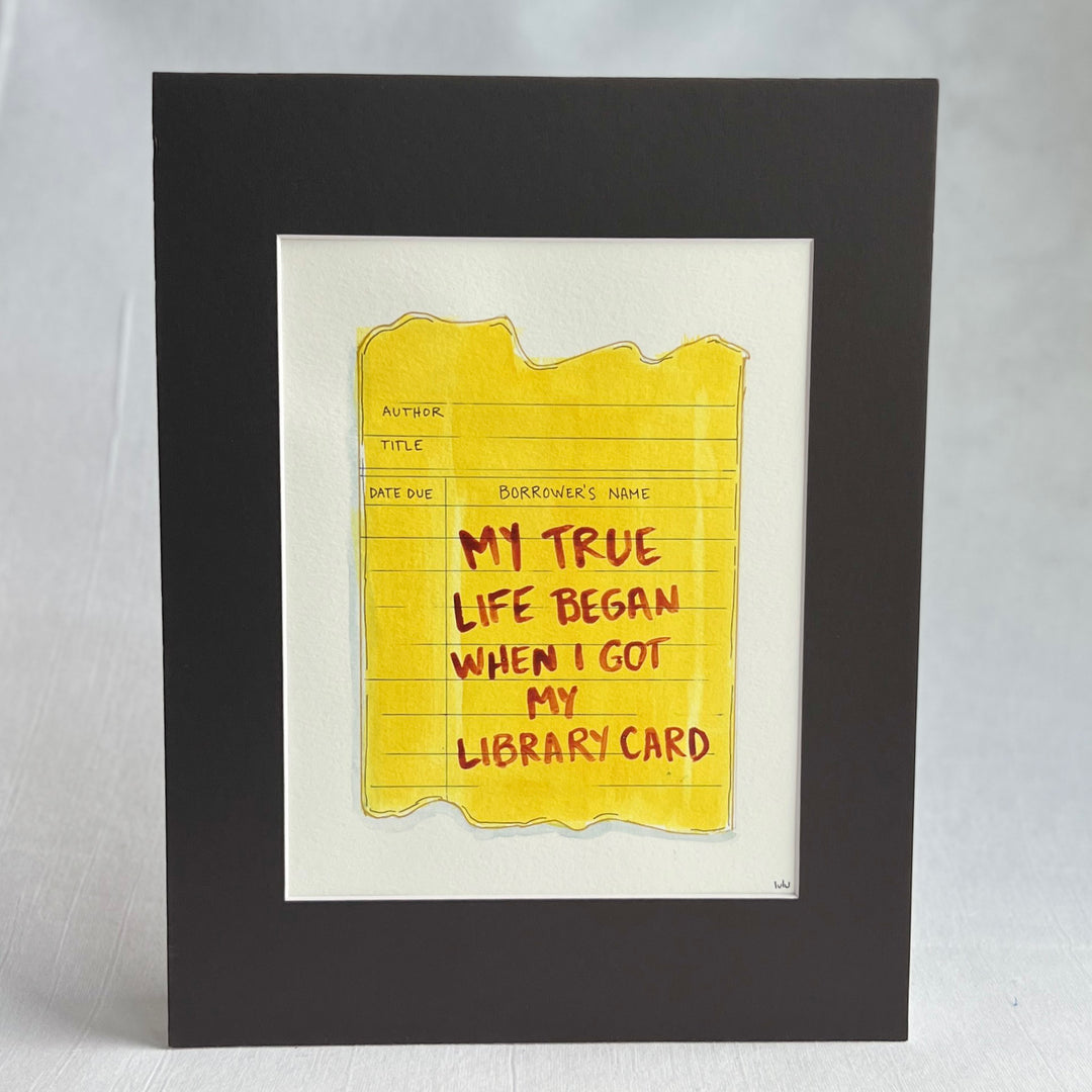 an original watercolor painting depicting a torn vintage library checkout card in shades of yellow with the words, my true life began when I got my library card, matted in black