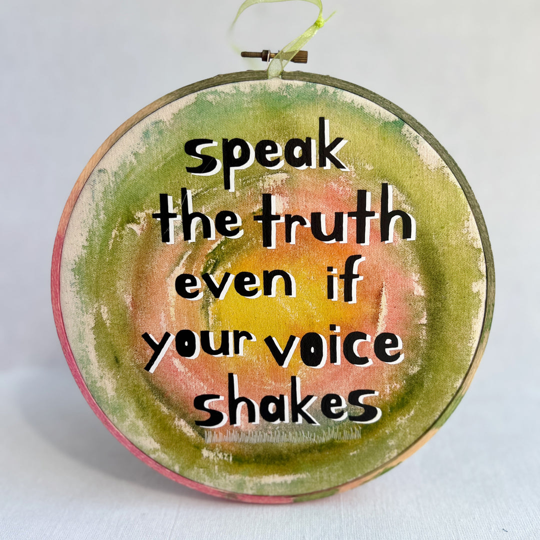 eight inch painted wooden embroidery hoop with canvas, painted with greens pinks and yellows, with the words, speak the truth, even if your voice shakes.