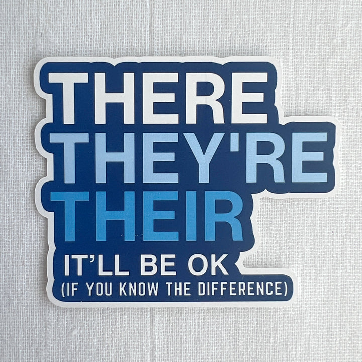 A word sticker with blue background and white lettering, with the words, "There They're Their. It'll be ok. If you know the difference.'