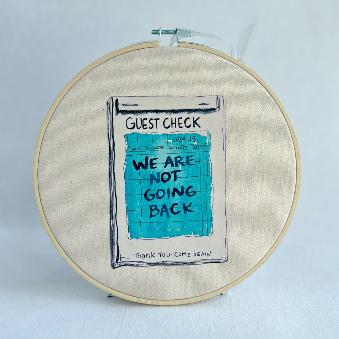 oatmeal linen canvas with a guest check design in deep blue-grey, with the words, we are not going back