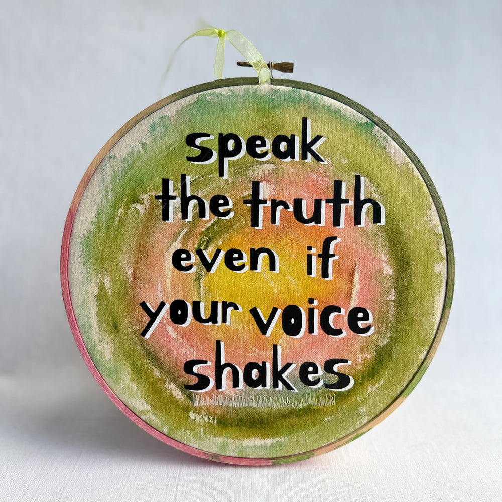 eight inch painted wooden embroidery hoop with canvas, painted with greens pinks and yellows, with the words, speak the truth, even if your voice shakes.