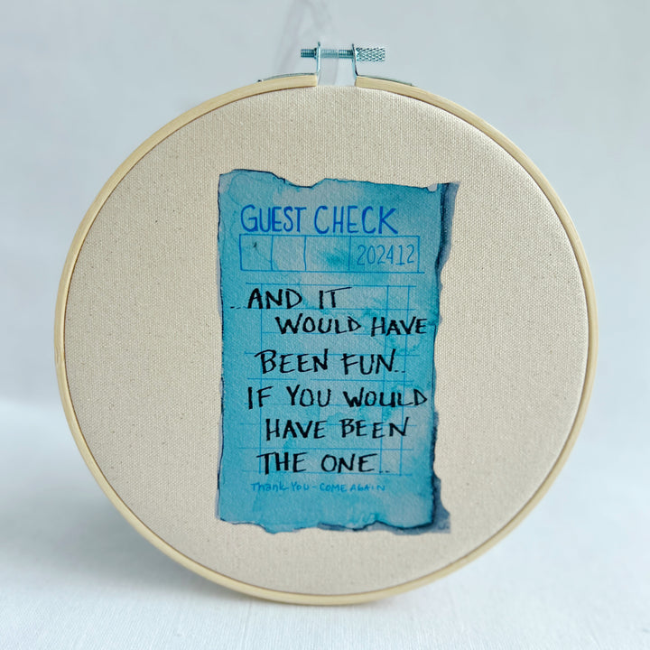 oatmeal linen canvas with a guest check design in deep blue, with the words, And it would have been fun, if you would have been the one. 